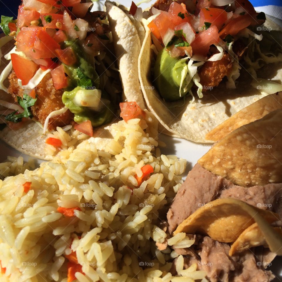 Fish tacos, rice, and refried beans
