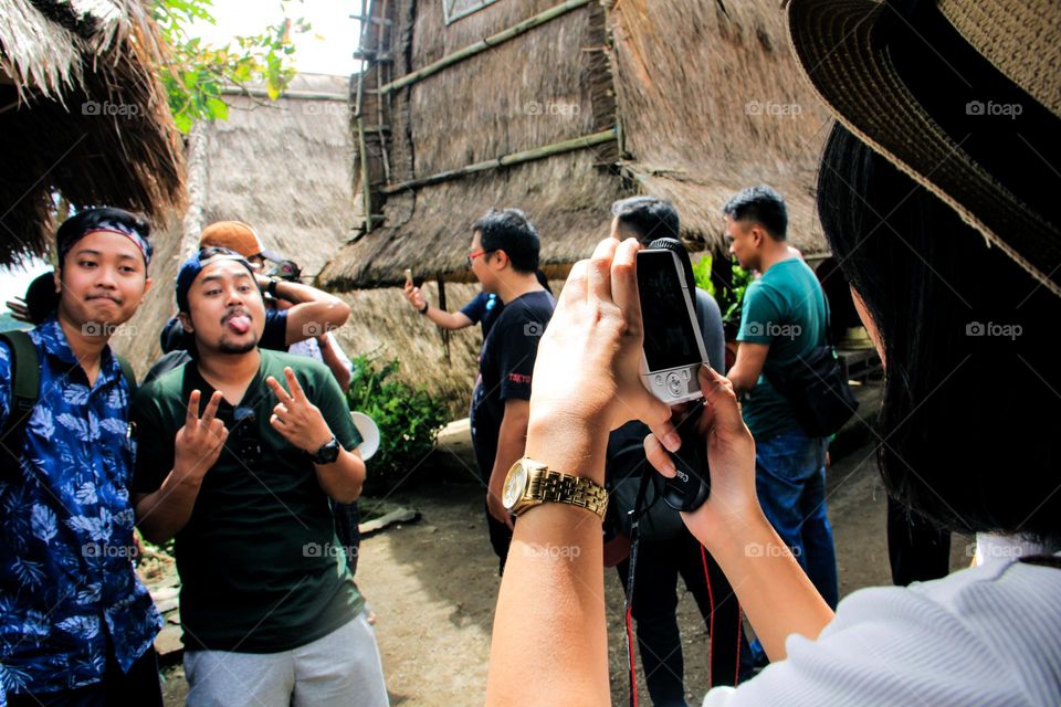 group portrait of asian tourists taking pictures with happy expressions.