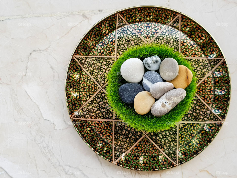 colourful pebbles on a grass vase on a beautiful plate