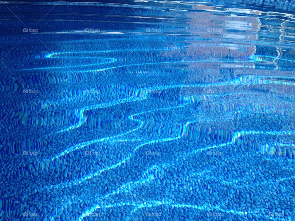 Ripples in the pool. Small waves of water in the swimming pool