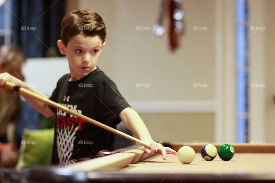 Boy playing snooker in home