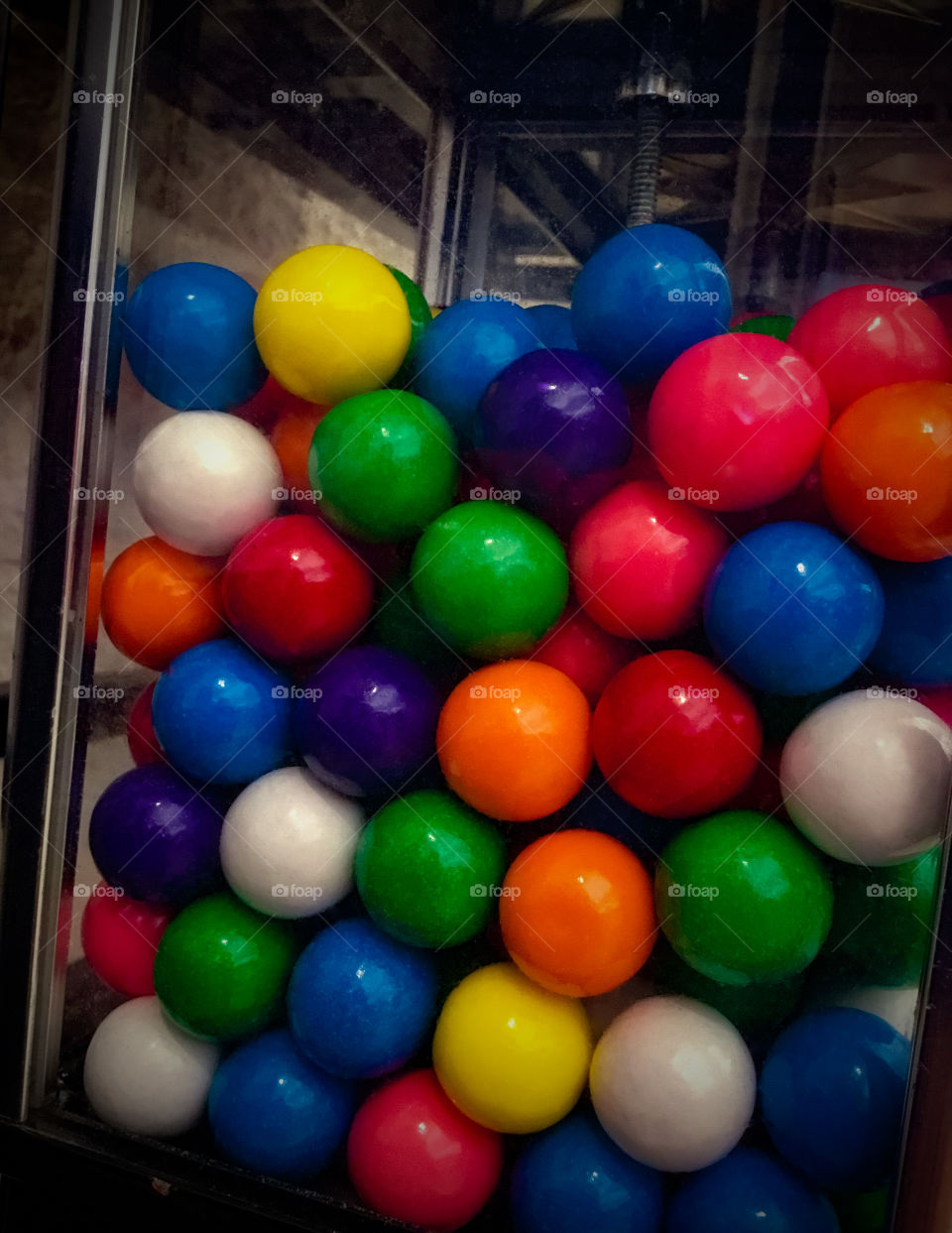 A colorful, vibrant gumball machine - looking through the glass.