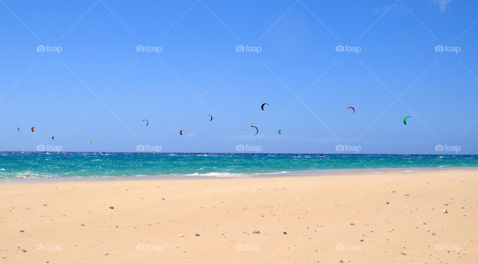 People paragliding over the beach