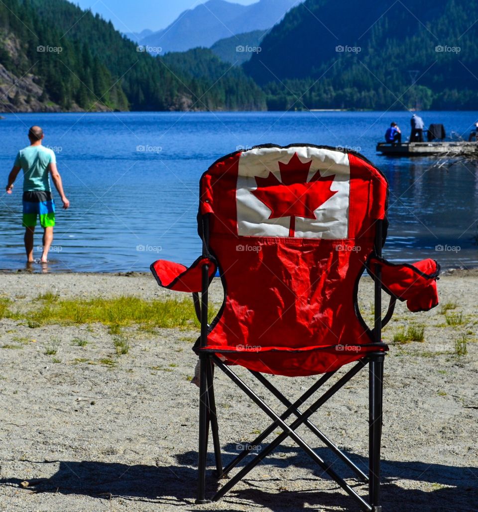 Supernatural British Columbia, Canadian flag chair on Buntzen lake a beautiful reservoir surrounded by mountains and old growth forest. Great family time, fishing