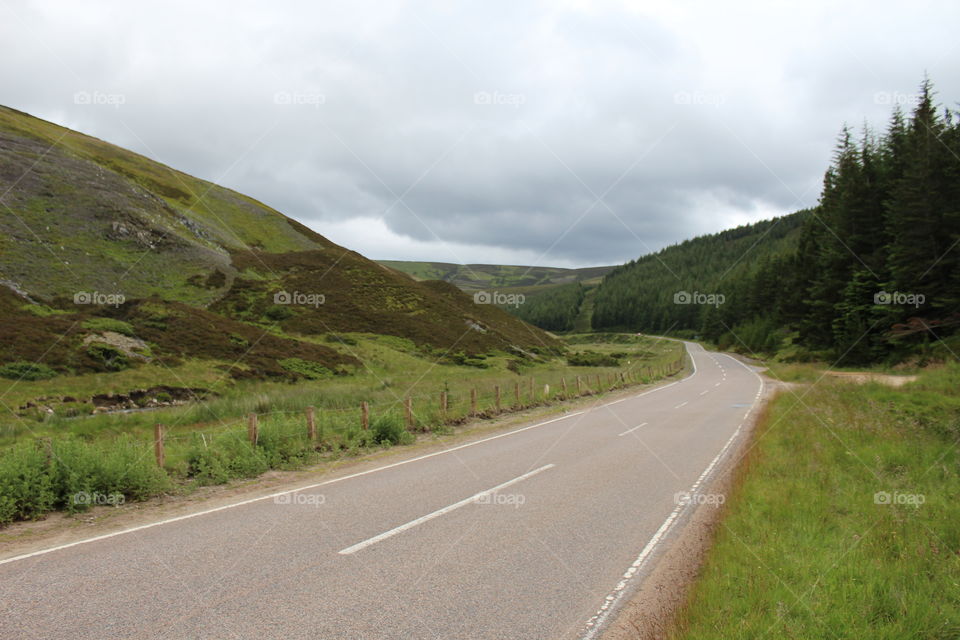 Scenic view of empty road against cloudy sky