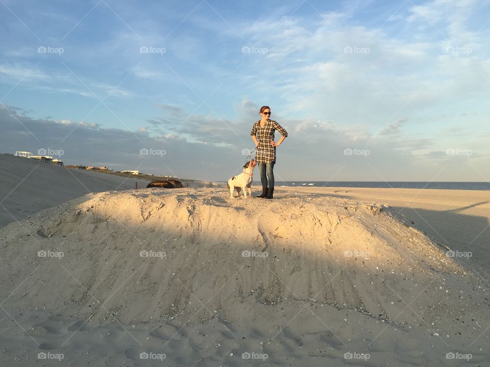 Me and my dog on top of a sand mound on the beach. 
