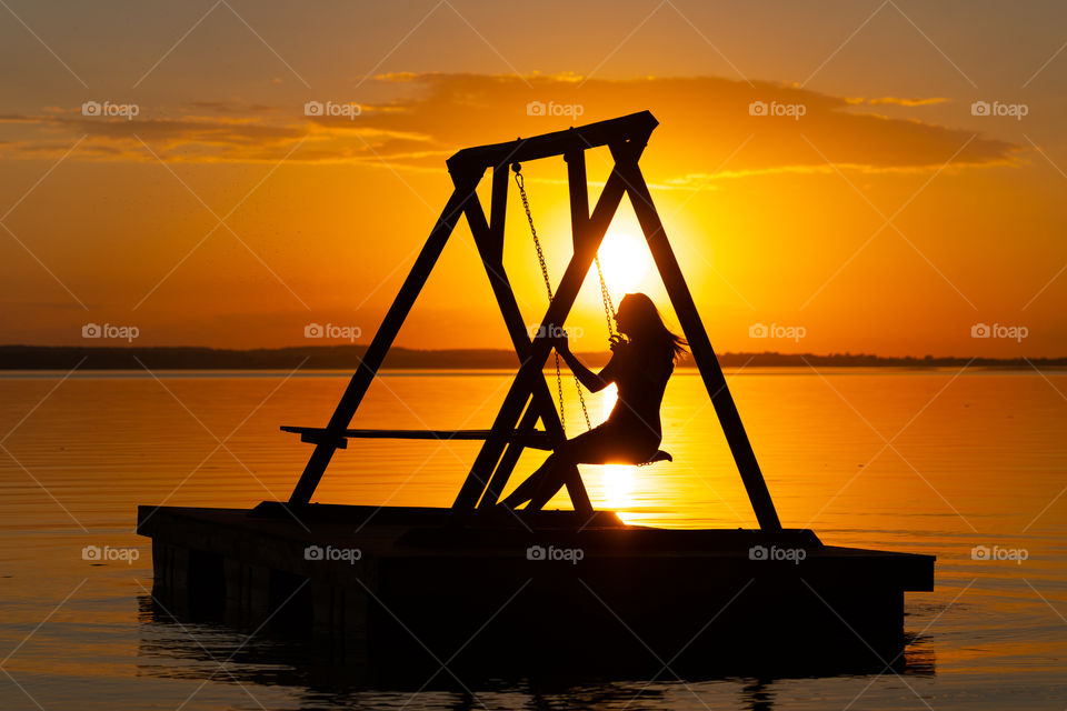 Warm summer evening. When is warm enough to watch the sunset on the lake.