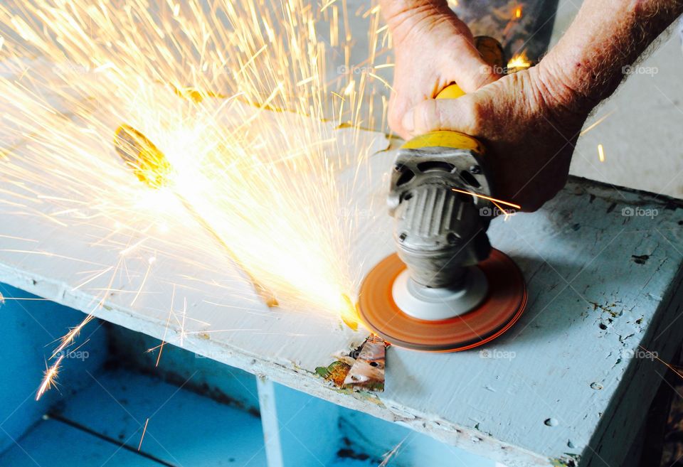 Hands of a worker using an angle grinder