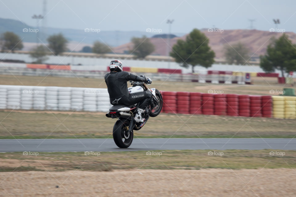 Speed motorbike doing a wheelie on track