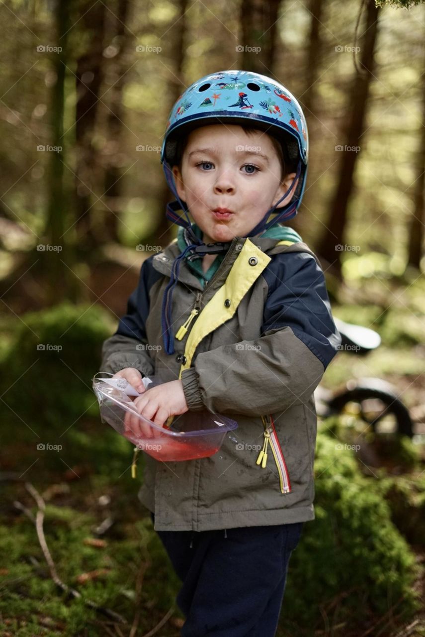 Boy in the forest eating watermelon