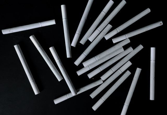 White cigarettes trickle in black background