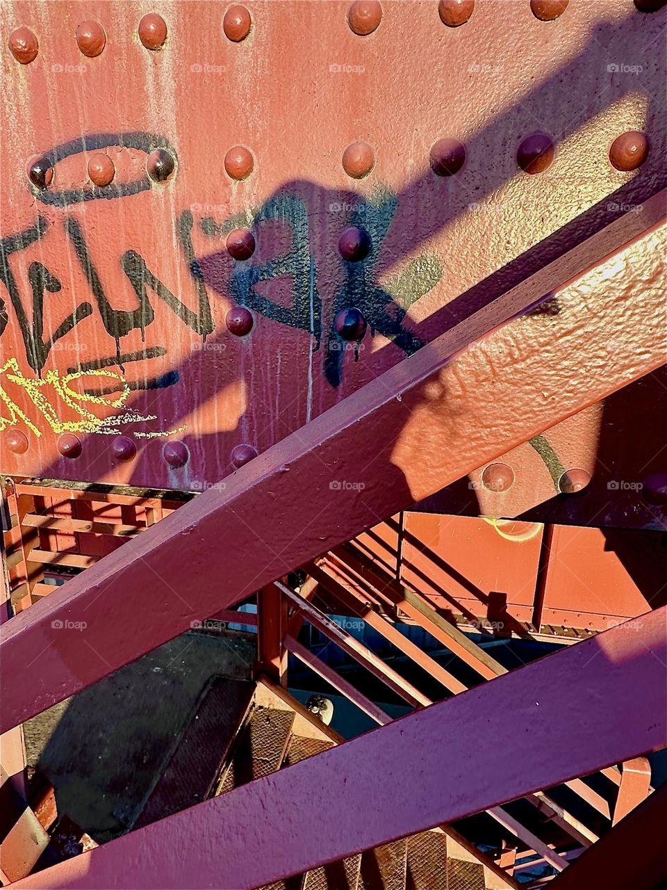 Interesting detail emerges in the late afternoon sun when descending on the red metal staircase of the “Pulaski Bridge” that connects “Greenpoint”, Bklyn to LIC, Queens at “Newtown Creek”, an ocean inlet of the “E River”. 2024. Hypnotic Productions