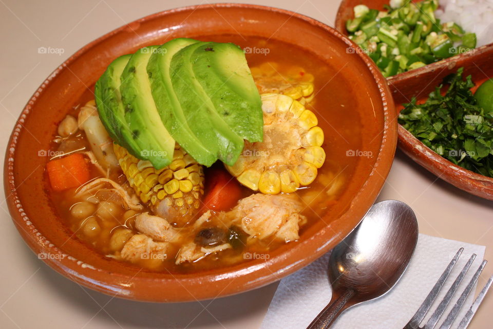 Caldo Tlalpeño. Mexican dish with avocado, chicken, carrot, corn, chili, onion, potatoes and authentic Mexican season.