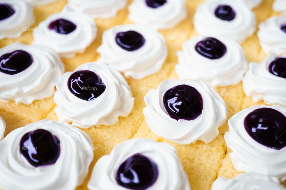 Blueberry cake. Butter cake with blueberry sauce and whipping cream on top, small serve.