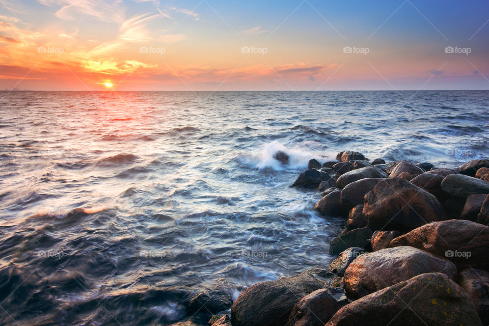 Harbor beach stones blue orange water sunset sunrise waves 