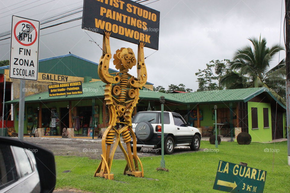 A man constructed of different car parts and painted yellow