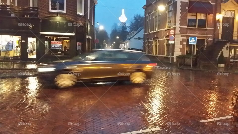 Moving car in a street on a rainy night in Lauren Holland