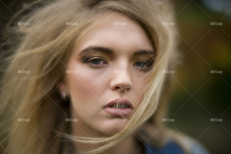 Model with messy blonde hair eyes follow