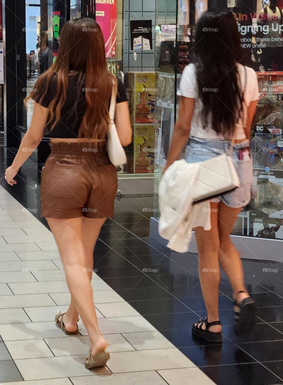 two women walking through an indoor mall shopping together as friends in Oregon