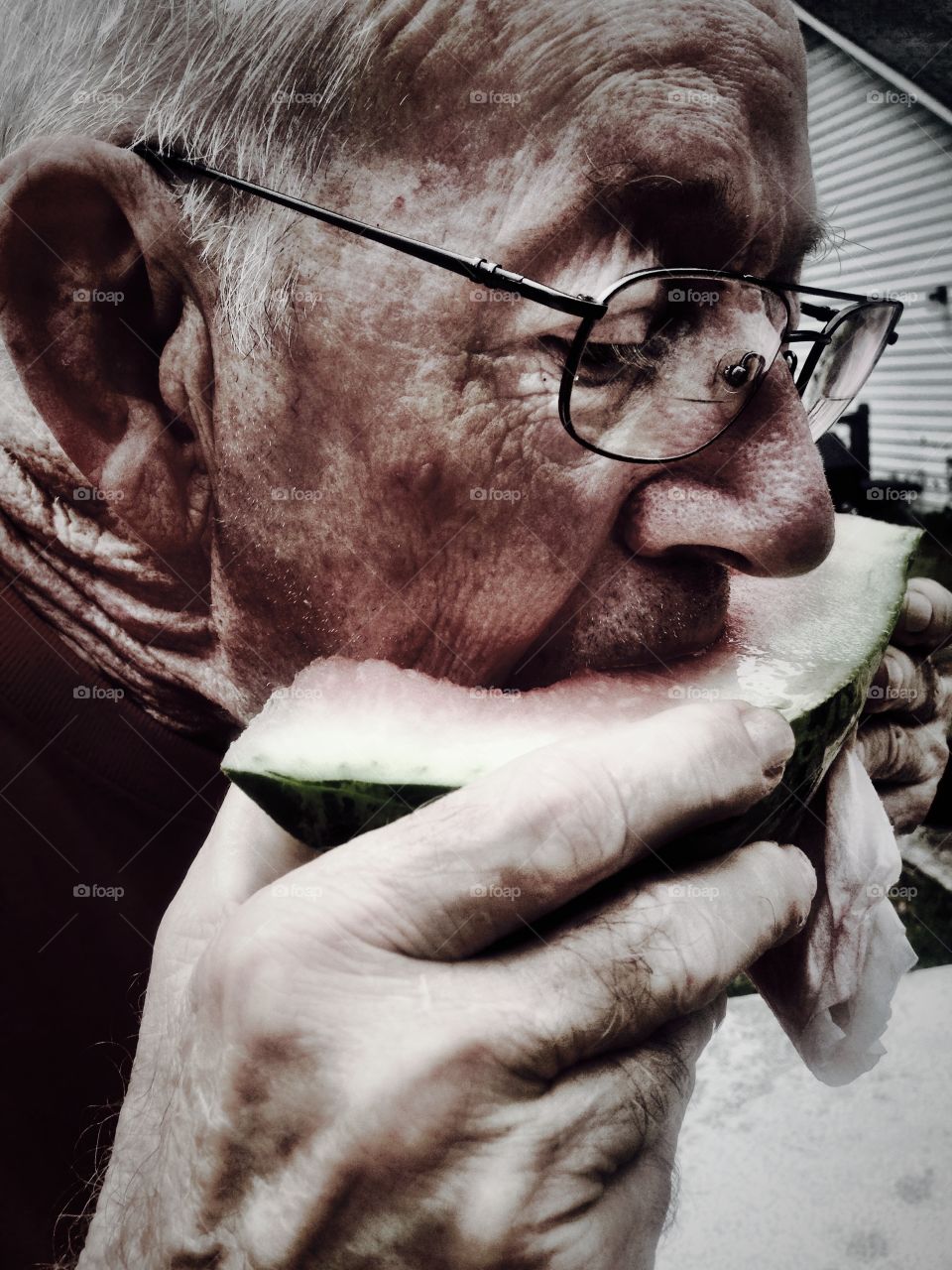 Senior man eating watermelon