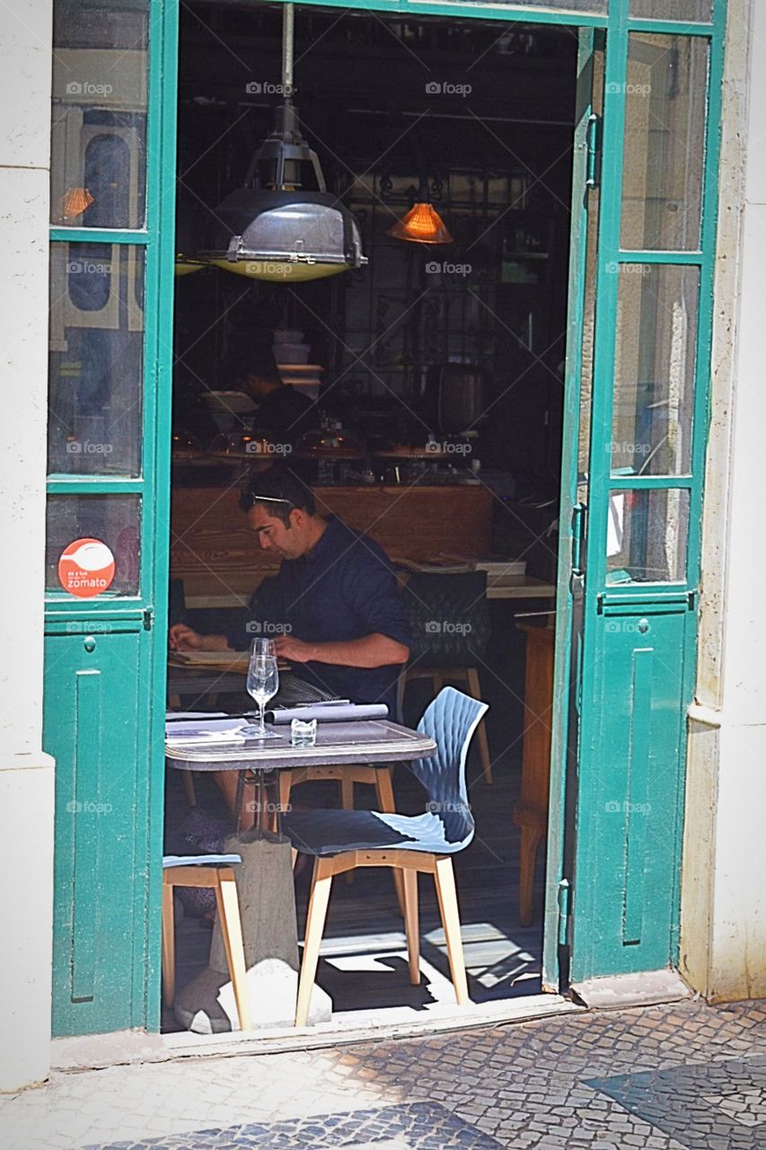 Man relaxing and reading paper in a local cafe 