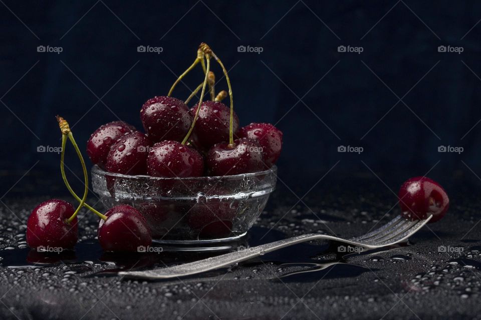 Red cherries on dark background. Heap of juicy wet cherries. Dessert concept.