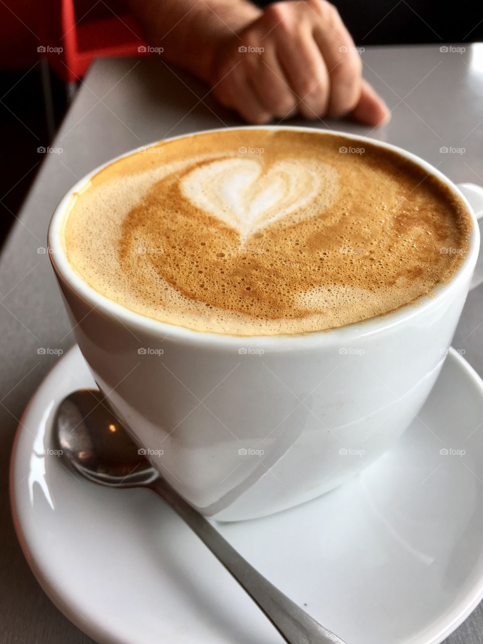 Frothy cup cafe latte heart shape design in cream