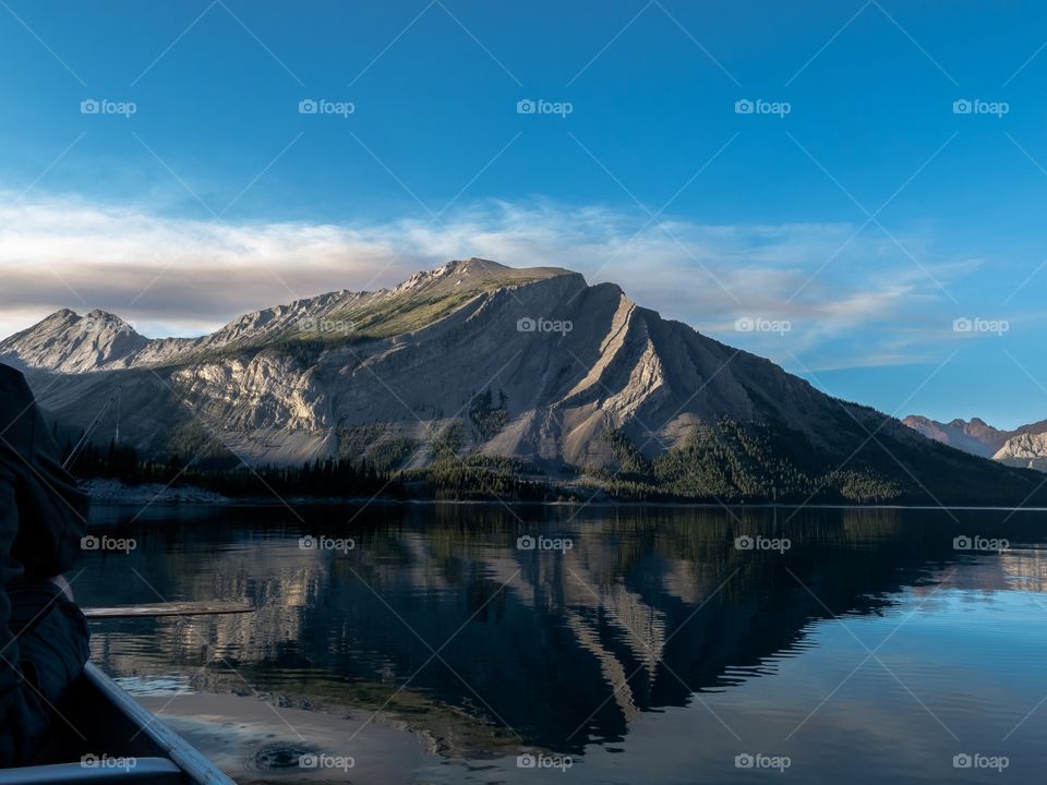 The mountain is reflecting in the water, while canoeing in a calm lake.