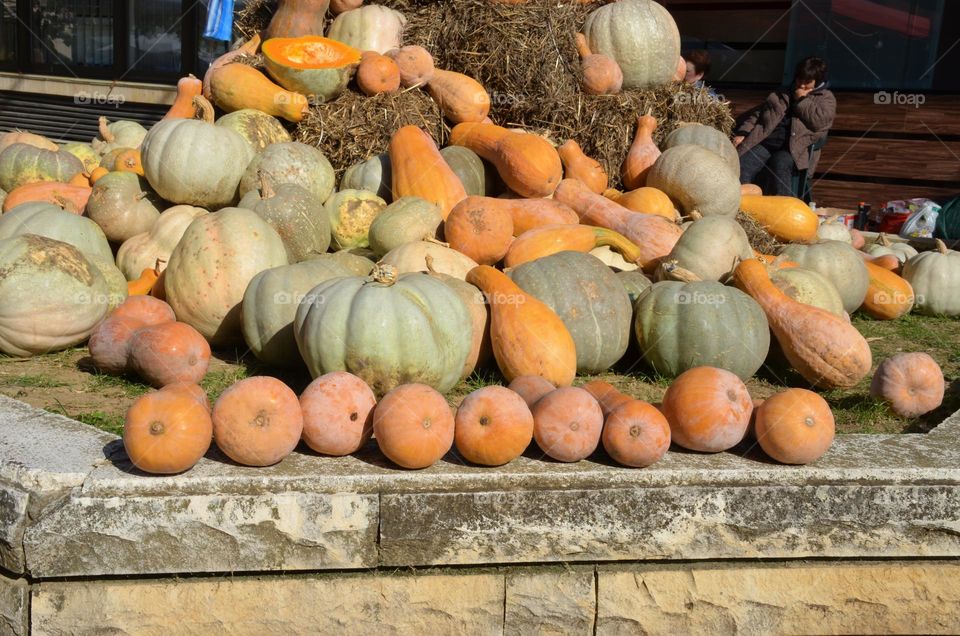 Pumpkins pile on hay stacks in street