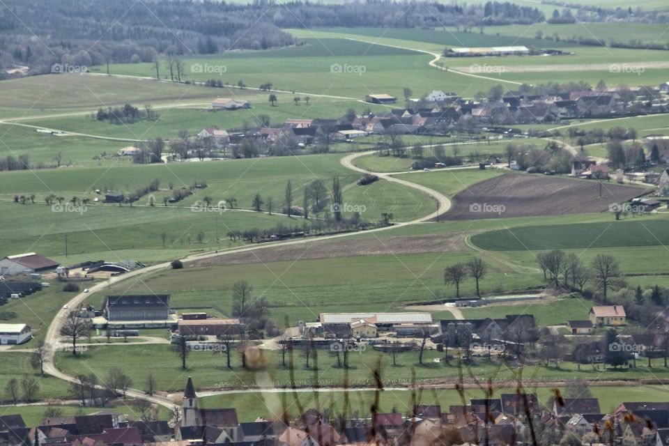 Aerial view over villages, agricultural fields and country road