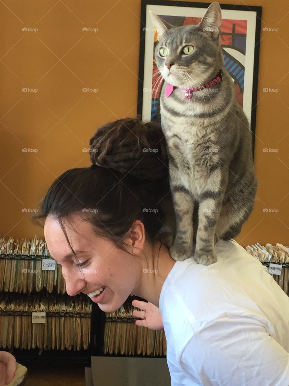 Cat sitting on woman's back