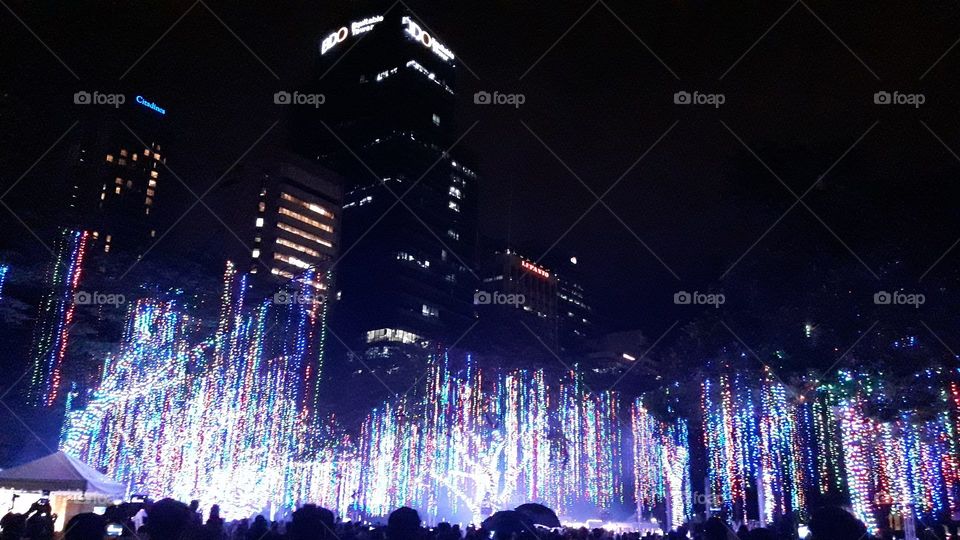Dancing lights in the middle of building and busy people Makati, Philippines on Christmas day.