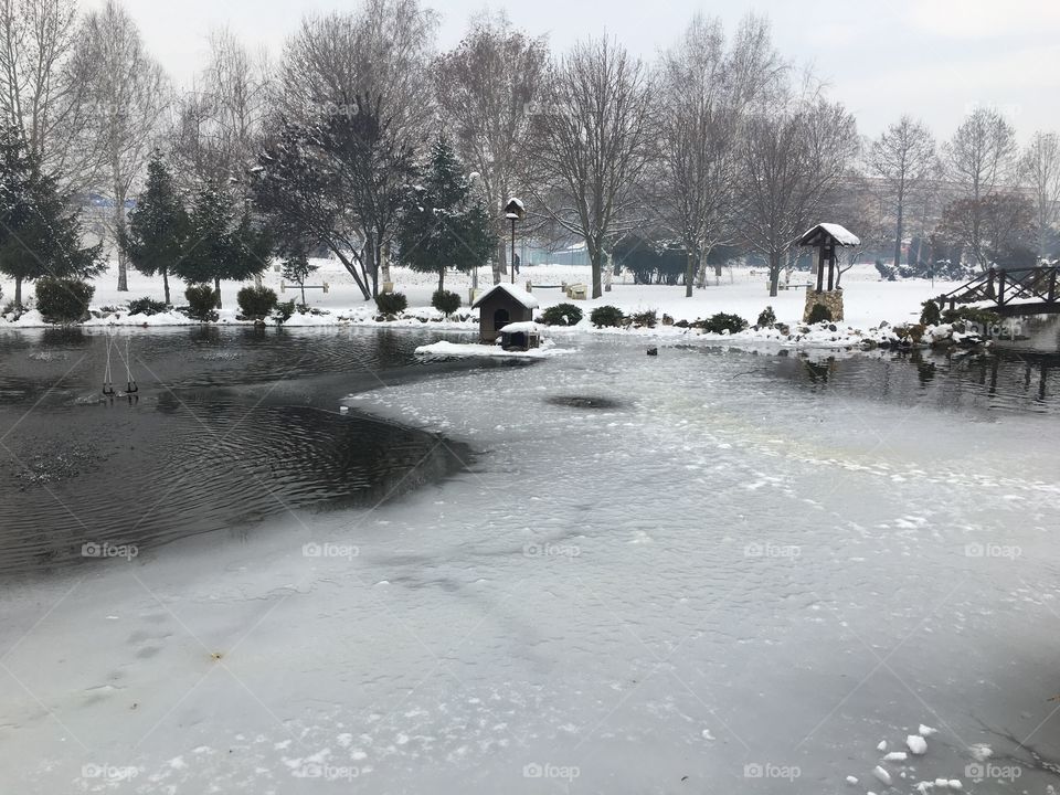 View of pond and picnic table during winter