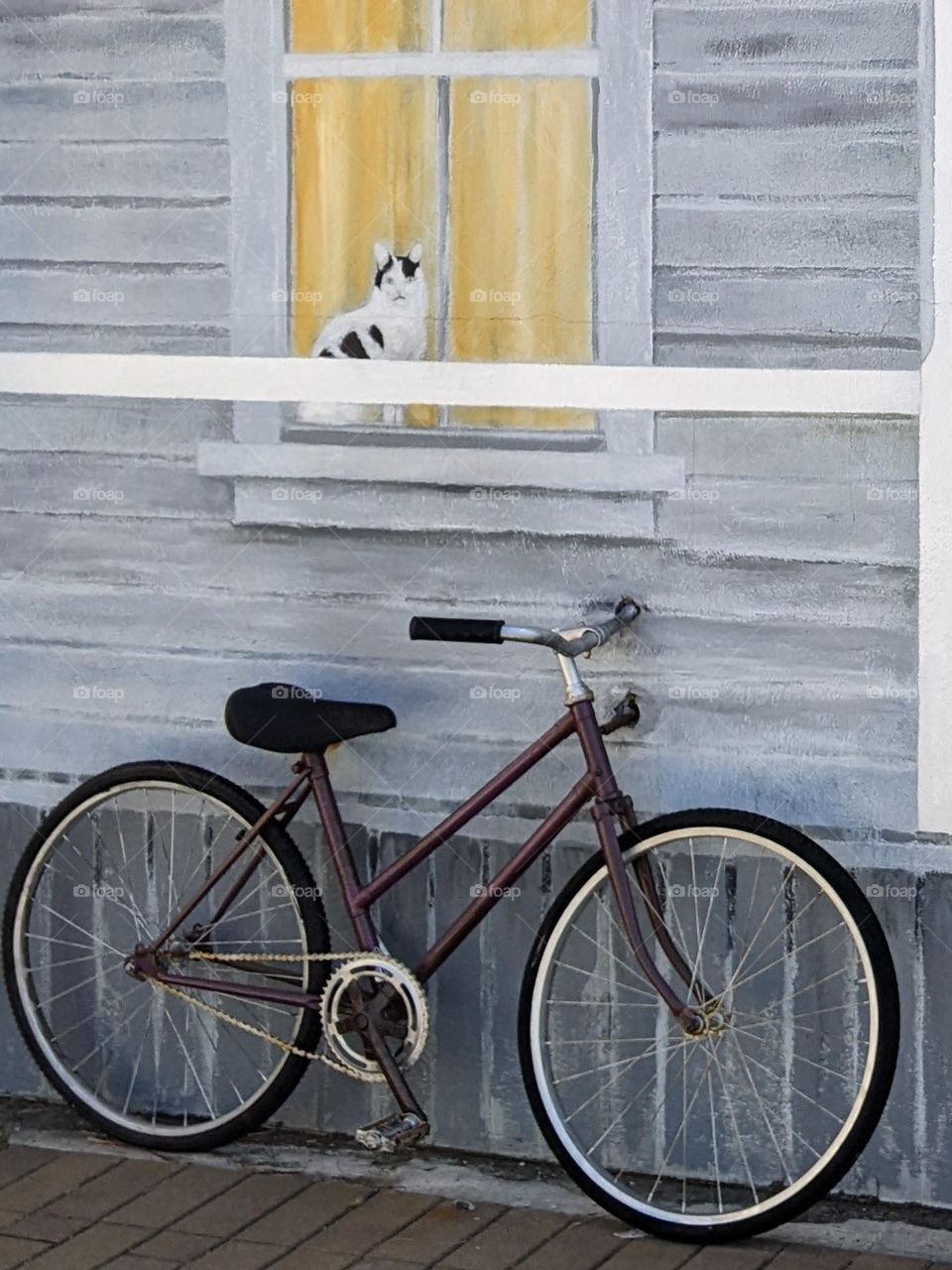 single bike underneath a painted window