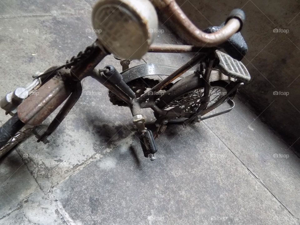 Old, rusty and broken toy bicycle