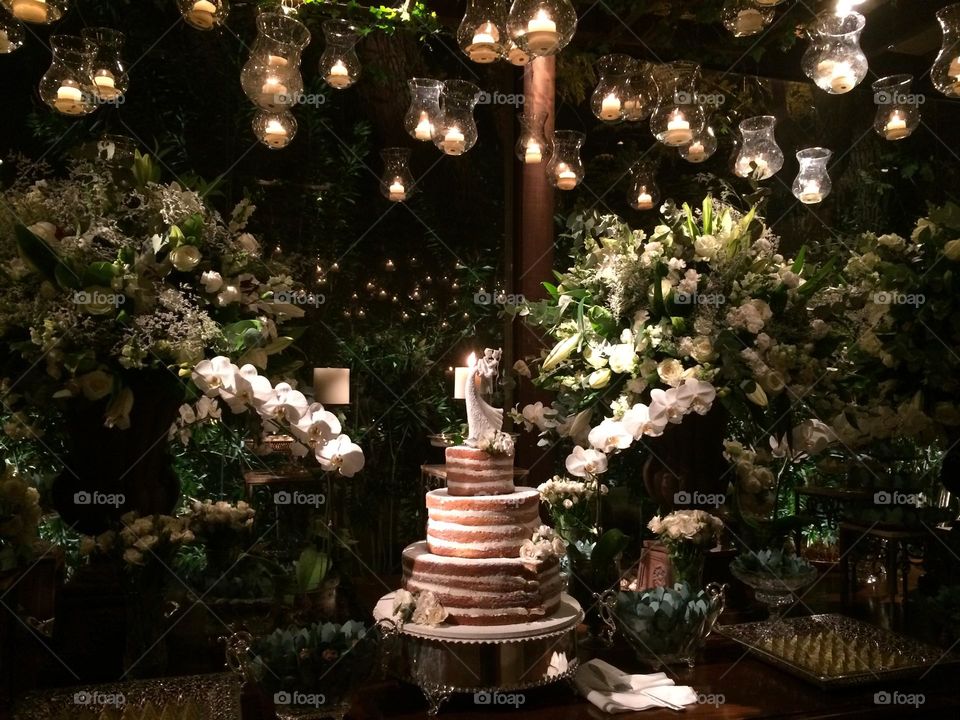 Wedding table with white flowers, candles a a naked cake