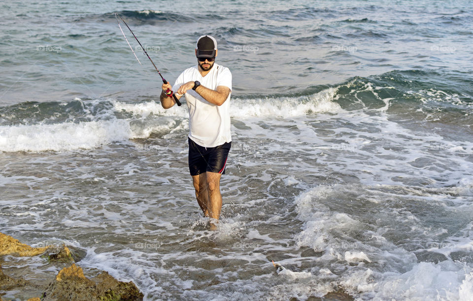 Fisherman hooks a makarel at the seashore