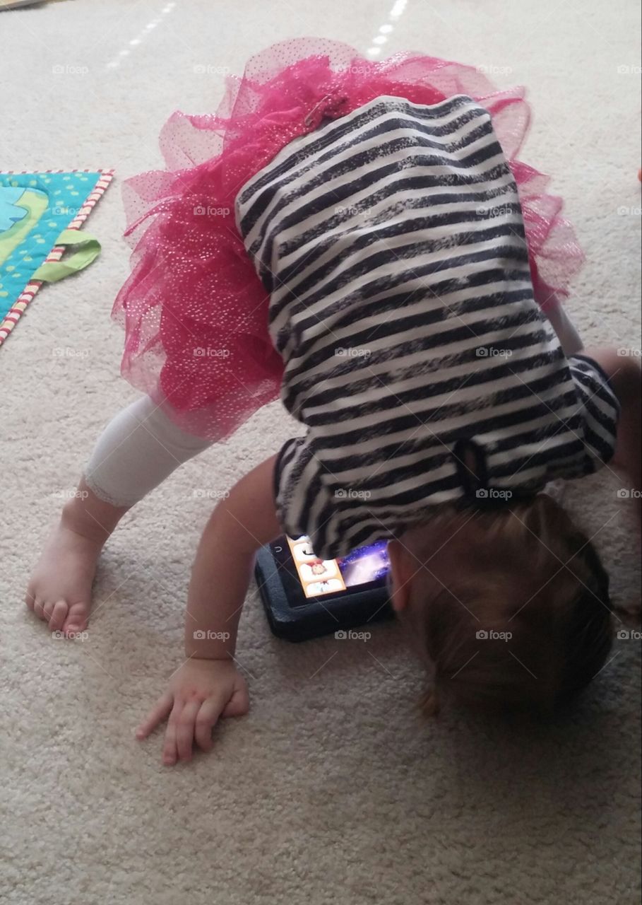 screen time. child on tablet doing head stand
