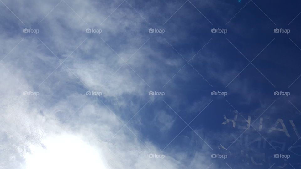 The sun illuminates the clouds in the deep blue sky.