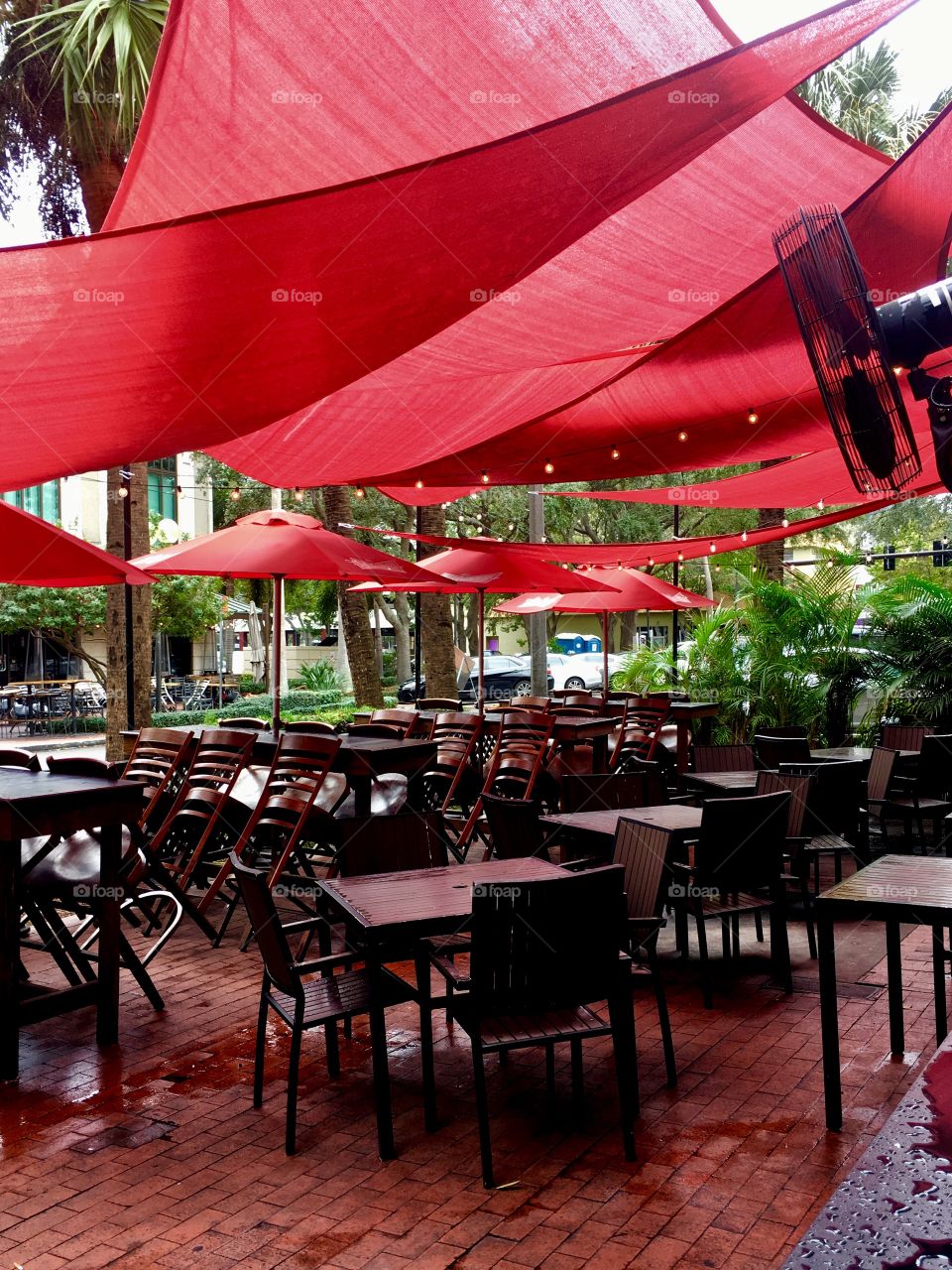 Sidewalk cafe with red shade sails and umbrellas 