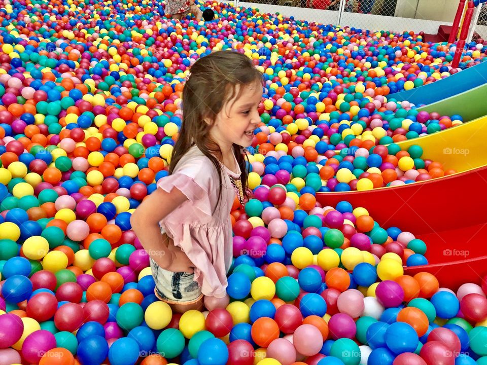 Girl standing in colorful balloons