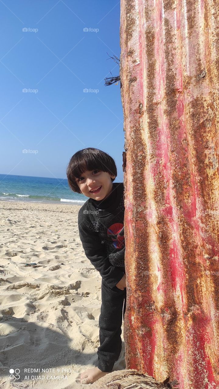 A spontaneous picture that I took of my little son, while we were having fun together on the seashore, in which there are many meanings of childhood