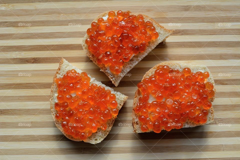 sandwiches with red caviar wood table background