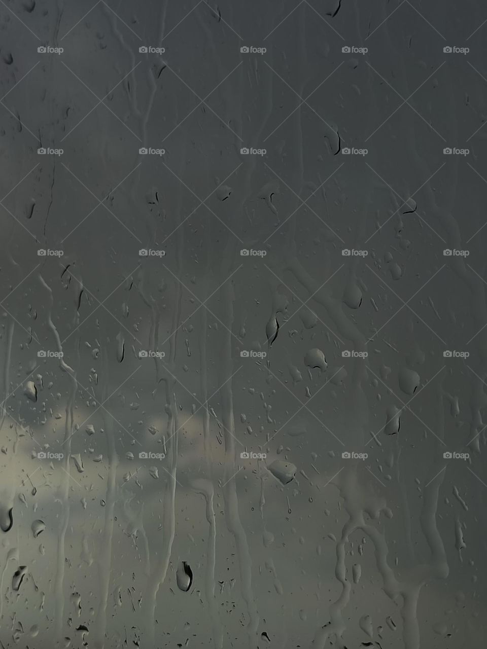 Raindrops on the winter glass, deep gray thunderstorm sky, rain clouds, background