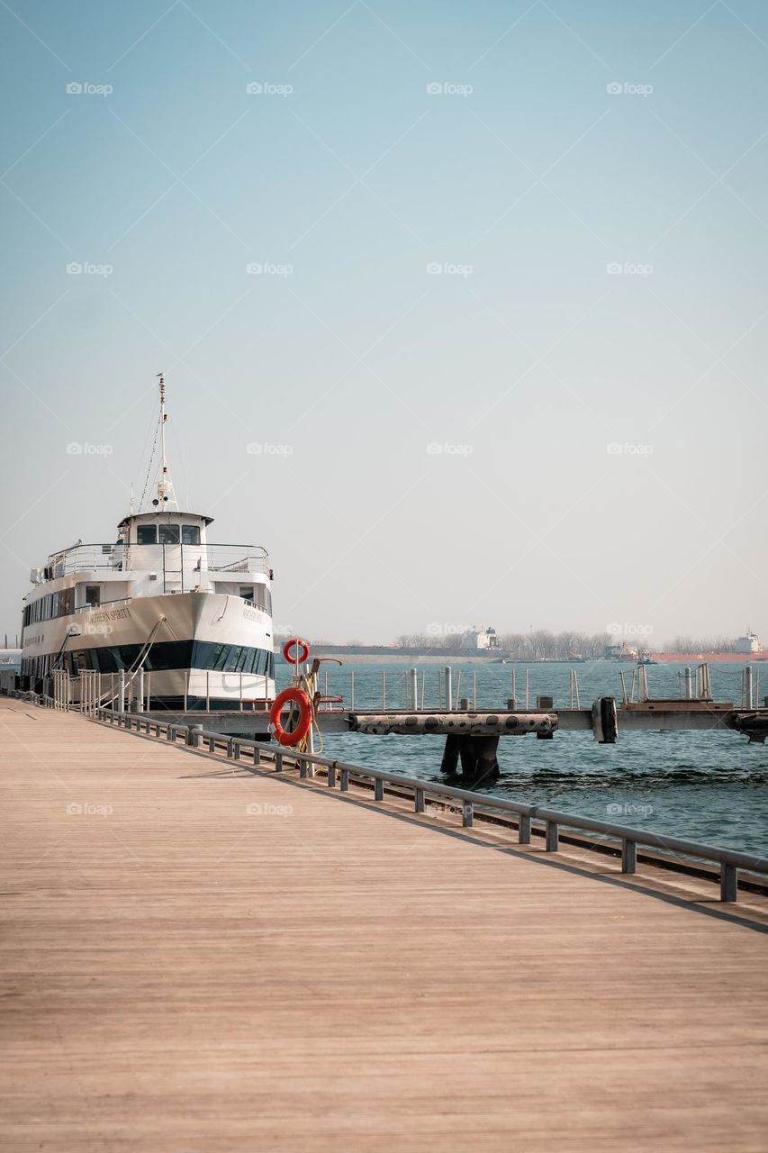 Large White Boat Docked By A Wooden Boardwalk