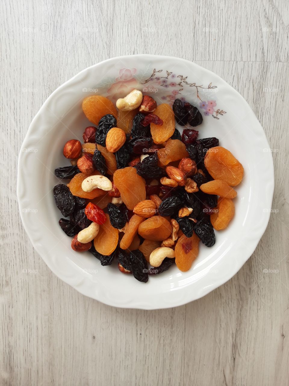 A dish of dried fruit with a mixture of nuts gives energy to athletes and benefits the owners of diet programs