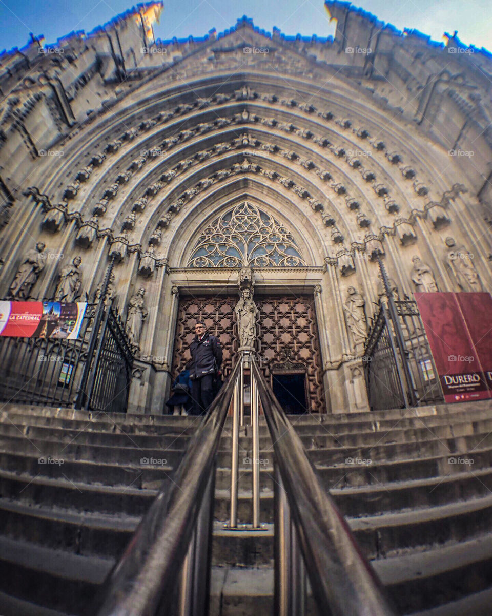 A wide angle image up the steps at the entrance to Barcelona cathedral, Spain