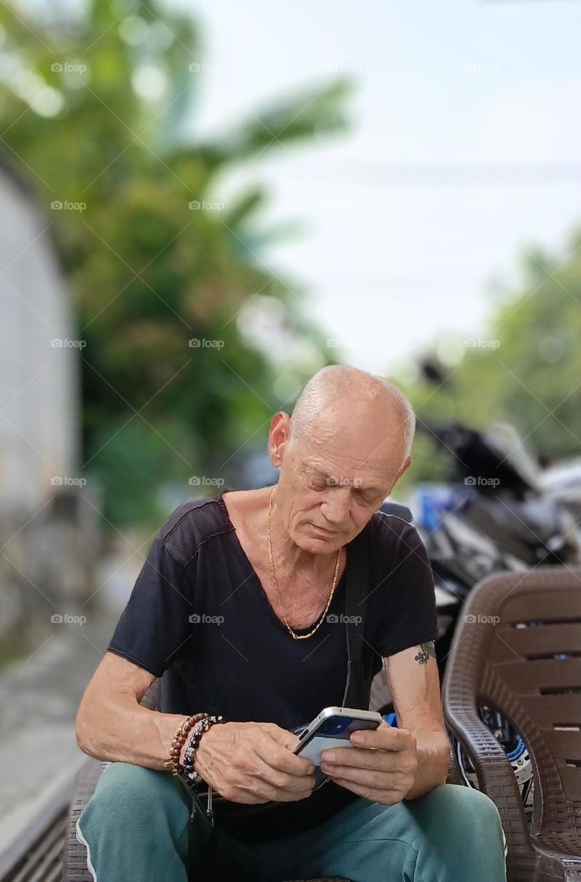 A man texting in his mobile phone.