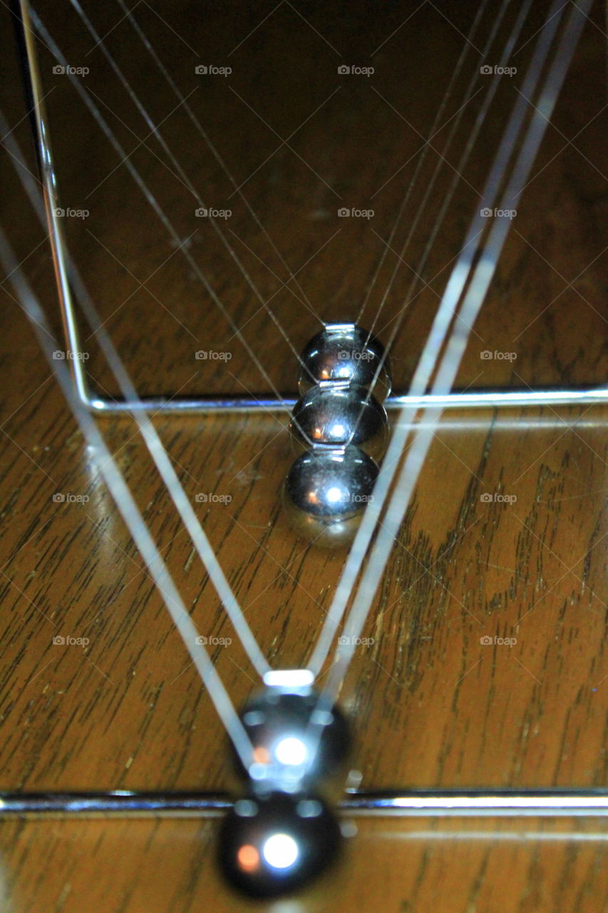 This is an up close picture of the balls from a Newtons Cradle swinging back and forth.