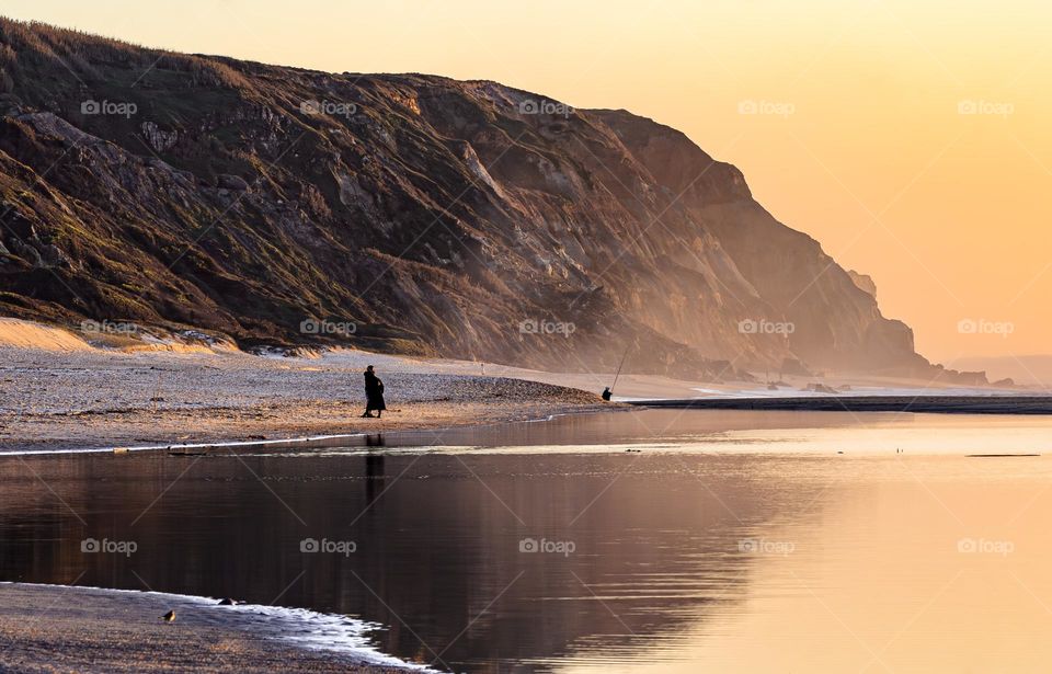 Sunset on the beach by the cliffs at Praia de Paredes da Vitória, Portugal 